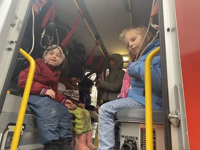 Die Schülerinnen und Schüler sitzen im Feuerwehrauto.