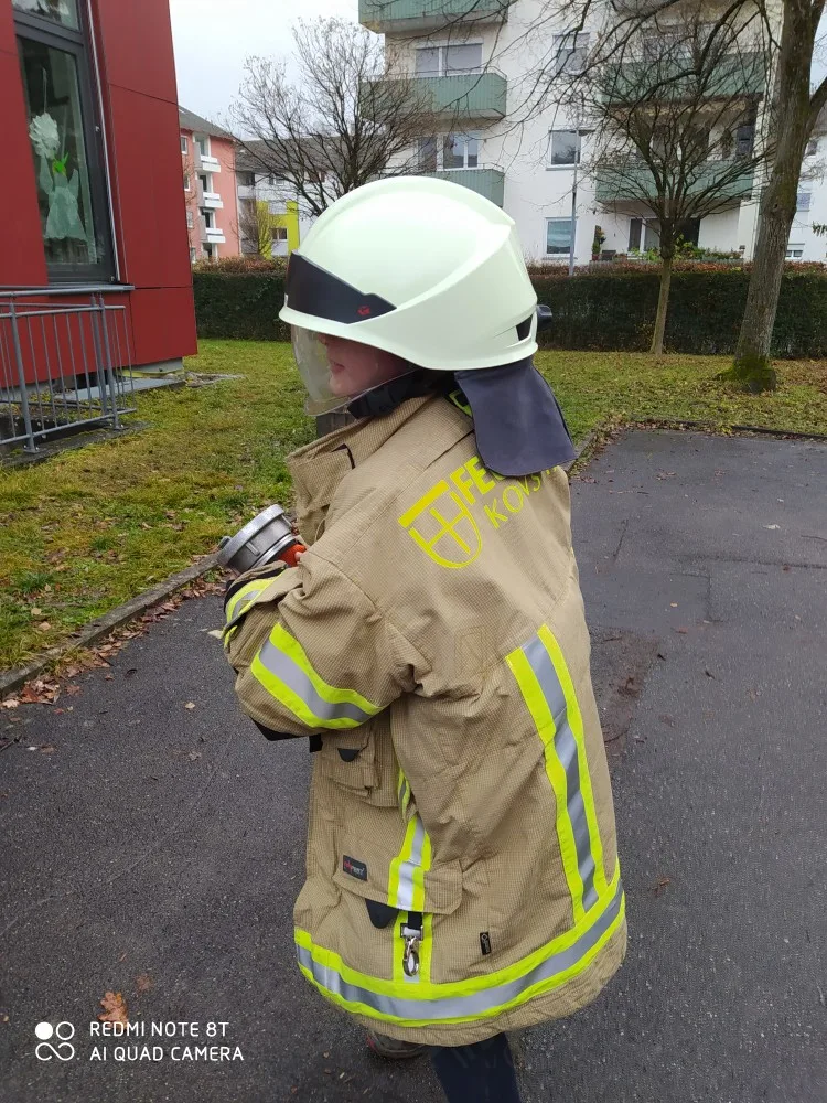 Feuerwehrtag mit einem verkleidet Schüler mit Feuerwehrhelm und Jacke.