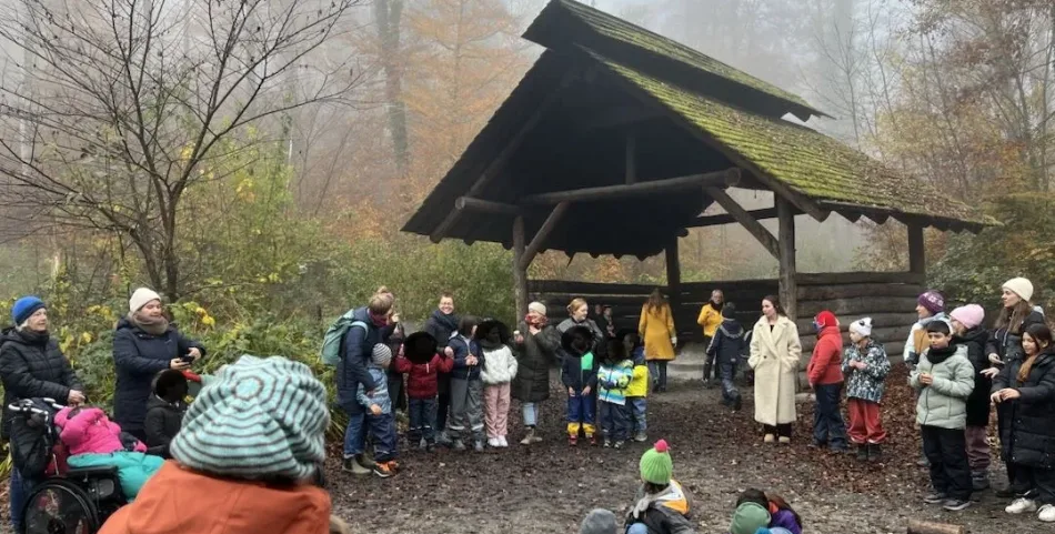 Die Schülerschaft und Lehrkräfte stehen an der Grillstelle im Nebel im Wald.